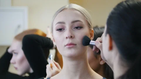 Models in the studio. Makeup artist contouring the models face with a brush Stock Footage 100282183