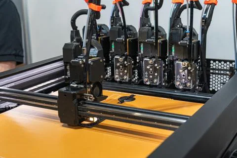 Modern 3D printer extrusion heads depositing material onto build platform, .. Stock Photos