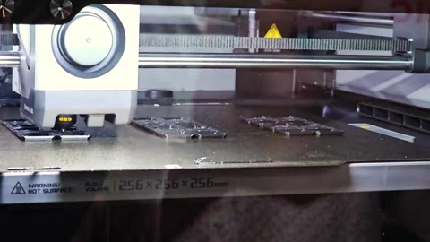 Modern 3D Printer Printing Small Plastic Parts on a Textured Build Plate Stockbeeldmateriaal 338056171