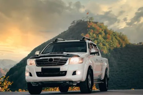 Modern 4x4 Pick-up truck on nature against to mountain in sunset Stock Photos