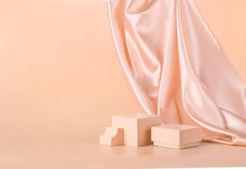 Modern abstract podium on pastel monochrome background with shiny draped fabric Stock Photos