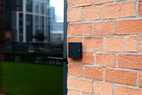 Modern access control system with RFID card reader attached to brick wall. Ph Foto stock