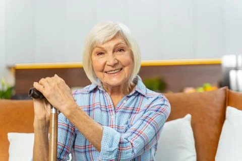 Modern aged lady with a cane smiling happily Stock Photos