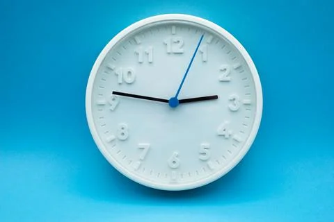 Modern analog clock on blue background Stock Photos