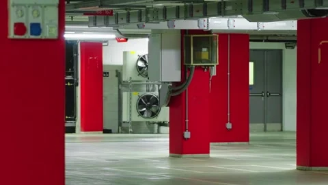 Modern and empty underground parking lot with bright red pillars, concrete Stock-Footage 337661403