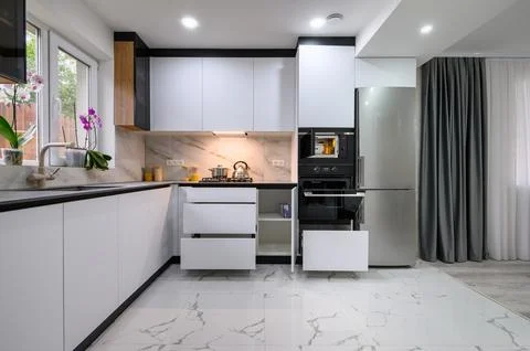 A modern and functional kitchen with a white design, a marble floor, an open Stock Photos