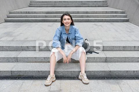 Modern and optimistic single lady resting on the street Stock Photos