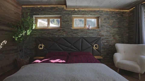 Modern and rustic bedroom interior with stone and wood walls, offering a scenic Vidéo 335198753