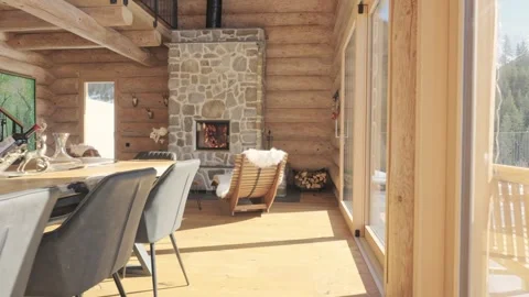 Modern and rustic living room in a wooden chalet with a cozy fireplace burning Stock Footage 334654868