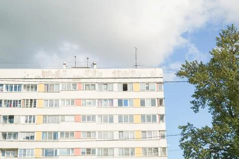 Modern apartment building with tree and partially cloudy sky. Urban housing Stock Photos