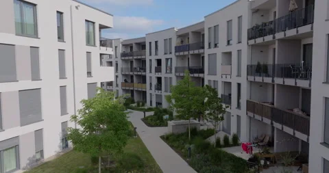 Modern apartment complex with balconies and green inner courtyard Stockbeeldmateriaal 329679762
