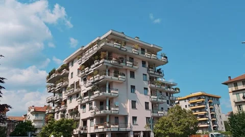 Modern apartment complex building against blue sky with white clouds Stock Footage 334630285