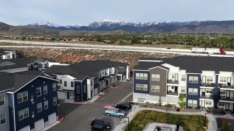Modern apartment complex with landscaped courtyard sits below highway in Reno Stock Footage 338419396