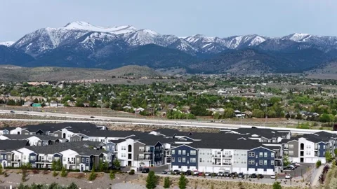 Modern apartment complex lines busy highway with passing traffic in Reno Stock Footage 338419323