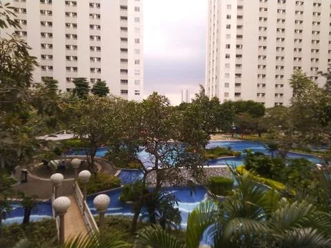 Modern Apartment Complex with Lush Greenery and Swimming Pool. Foto stock