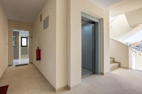 Modern apartment corridor with elevator, staircase and open entrance to res.. Foto stock