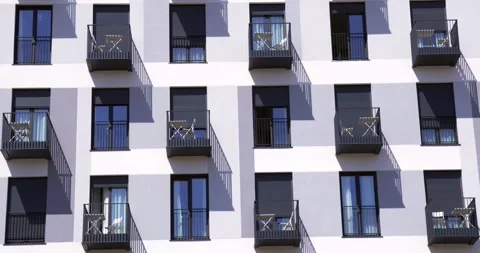 Modern apartment facade with repeating balconies and geometric shadows Stock Footage 336582434