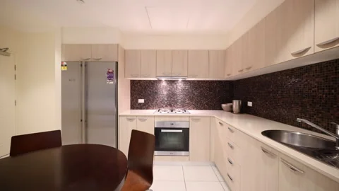 Modern Apartment Kitchen with Brown Tiled Backsplash And Stainless Steel Stock Footage 266985642