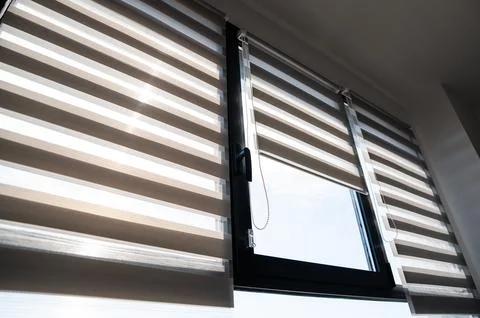 Modern apartment window with zebra roller blinds and chain control system Foto stock