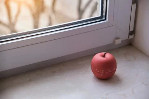 Modern apple shaped timer next to windows Stock Photos