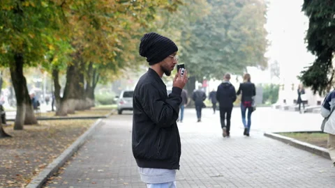 Modern Arab man stylishly dressed used mobile phone, calling in slow motion at Stock Footage 196805324