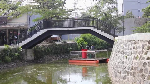 Modern Arch Bridge with Greenery and Calm Water Surface on a Sunny Day Stock Footage 336550441