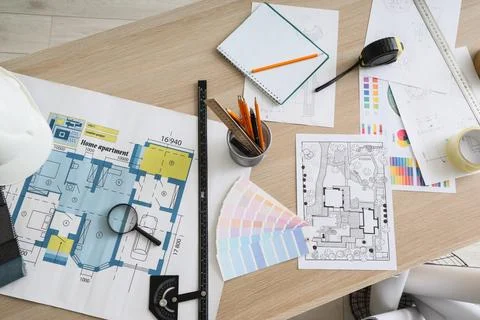 Modern architect's workplace with hardhat, blueprints and tools, closeup Stock Photos