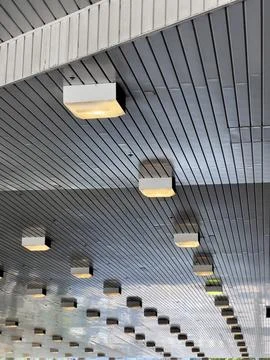 Modern architectural ceiling with linear metal slats, integrated lighting Stock Photos