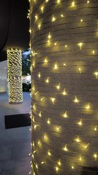 Modern architectural columns decorated with glowing yellow fairy string lights 库存照片