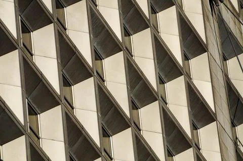 Modern architectural facade with repeating geometric patterns in urban sunlig Stock Photos