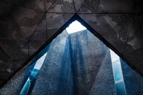 Modern architectural interior with geometric ceiling and textured walls loo.. Stock Photos
