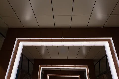 Modern architectural interior with geometric square light frames and brown Stock Photos