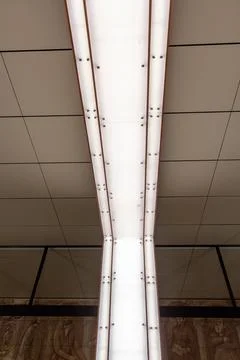 Modern architectural interior with linear ceiling lighting and decorative Stock Photos