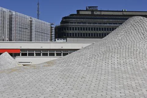 A modern architectural scene, emphasizing a unique, undulating rooftop patt.. Stock Photos