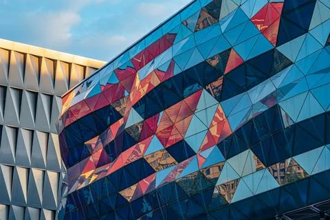 Modern Architectural Structure with Geometric Facade and Reflective Panels Stock Photos