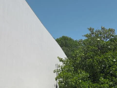 Modern architectural wall with sharp geometric angle against bright blue sky, Stock Photos