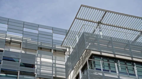 Modern architecture featuring glass facade with angular metal structures re.. Stock Footage 303953677
