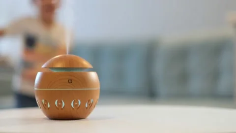 Modern aroma oil diffuser on the white table. A little boy in the background Stock Footage 170542633