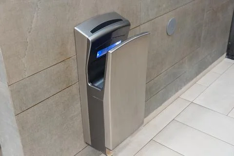 This modern automatic hand dryer is installed in a clean bathroom, providin.. Stock Photos