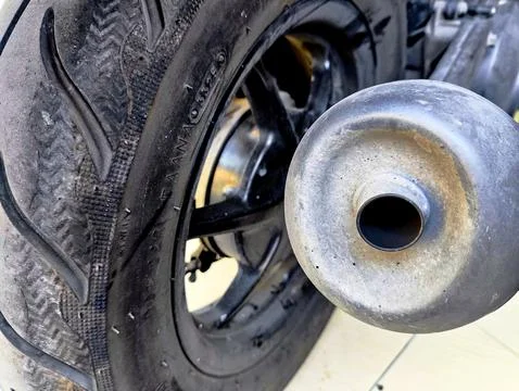 Modern automatic motorcycle rear wheel and standard exhaust pipe close up. Stock Photos