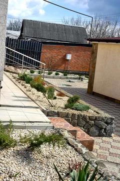 Modern backyard landscape design with stone raised garden bed, decorative plants Stock Photos
