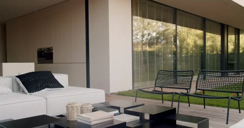 Modern Backyard Patio with Sofa, Wicker Chairs, and Open Concept Kitchen Stock Footage 344273718