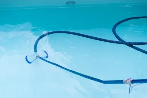 Modern backyard pool with underwater cleaning equipment showing maintenance.. Stock Photos