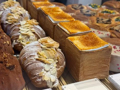 Modern bakery display with cube pastries topped with caramelized sugar and .. Stock Photos