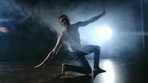 Modern ballet, a man from a sitting position on the stage jumps backflip with Stock Footage 120904696
