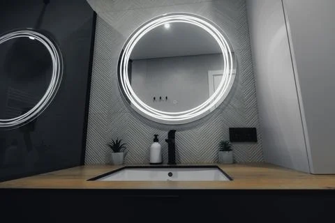 Modern bathroom with circular lighted mirror Stock Photos