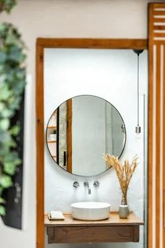 Modern bathroom design featuring round mirror and minimal decor elements Stock Photos
