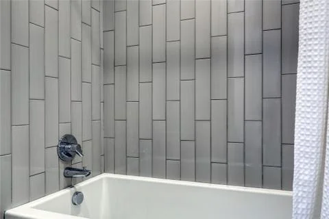 Modern bathroom design featuring shower nook with grey vertical shower surrou Stock Photos