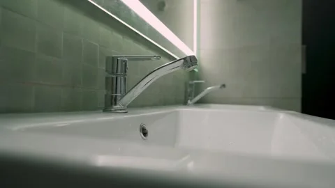 Modern bathroom design light turns on, young man enters and washes his hands  Video stock 270519292