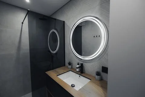 Modern bathroom features sleek design with circular mirror Foto stock